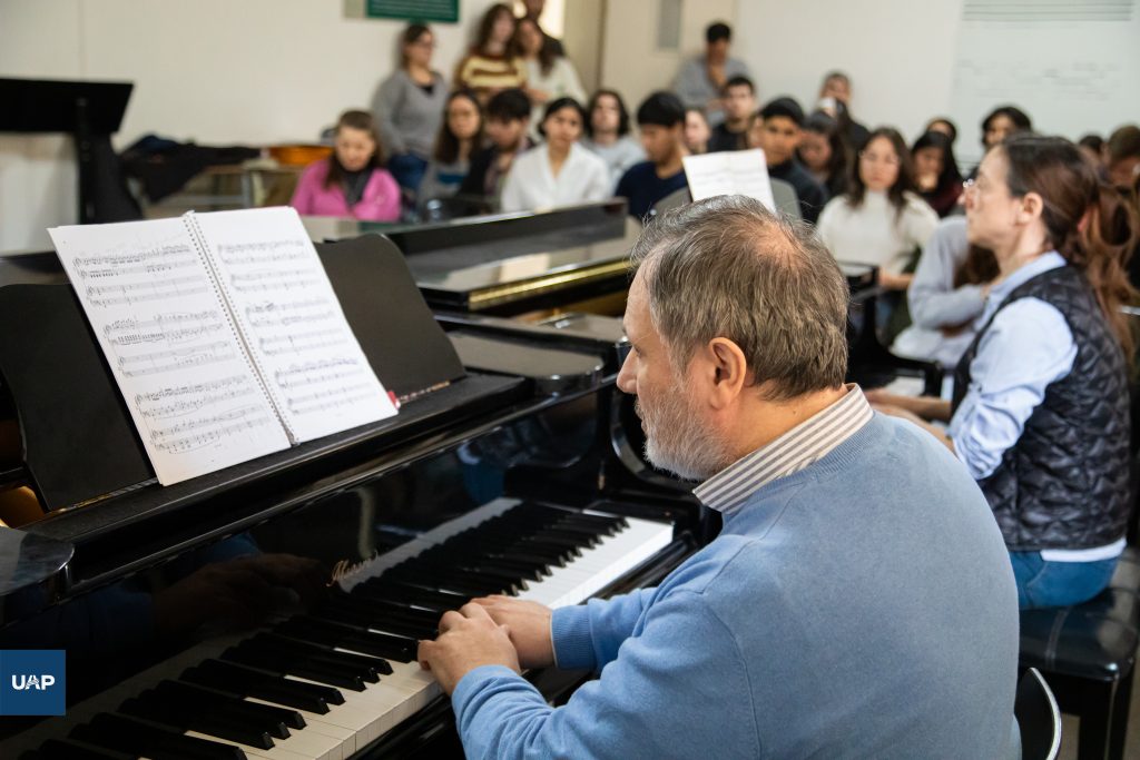 Iván Cítera impartiendo el taller de piano a los estudiantes de Música.