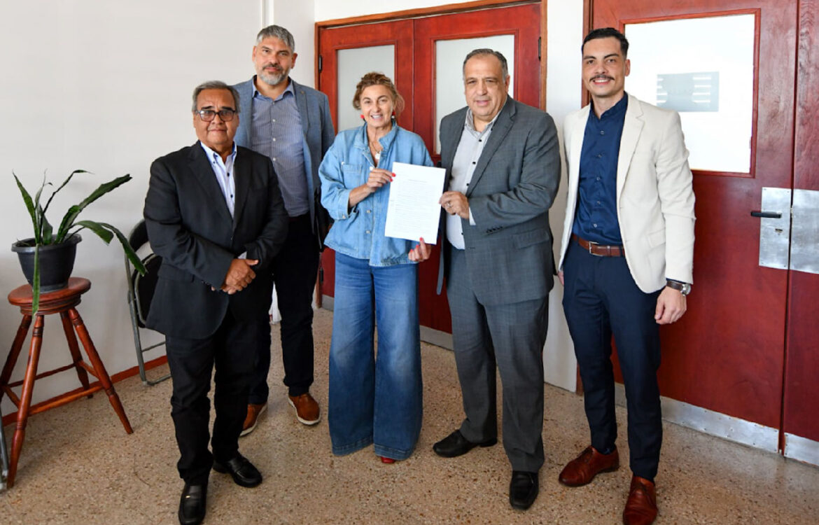 Lic. Fregonese y el Mag Rizzo sostienen el documento rubricado