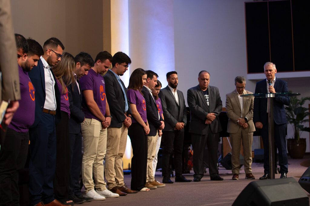 El Pr. Darío Caviglione ora por los nueve voluntarios UAP que prestarán servicio por un año en diferented lugares del mundo