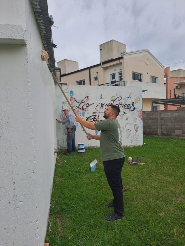 Componentes del personal pintanto las paredes de la Escuela Esperanza.