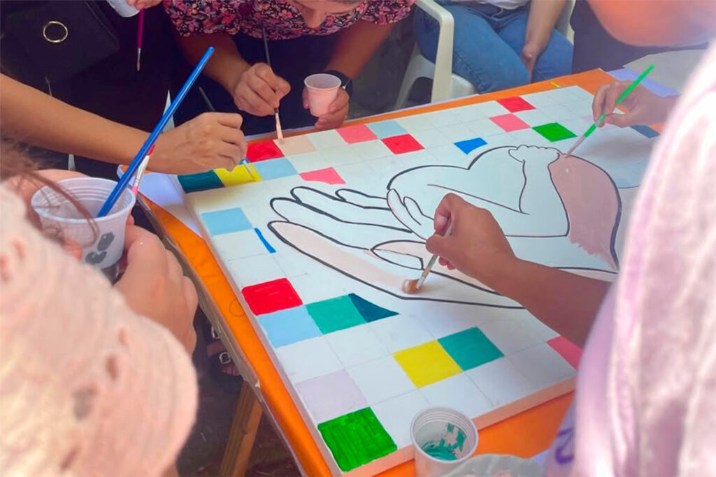 Personas realizando un obra artística sobre el autocuidado.