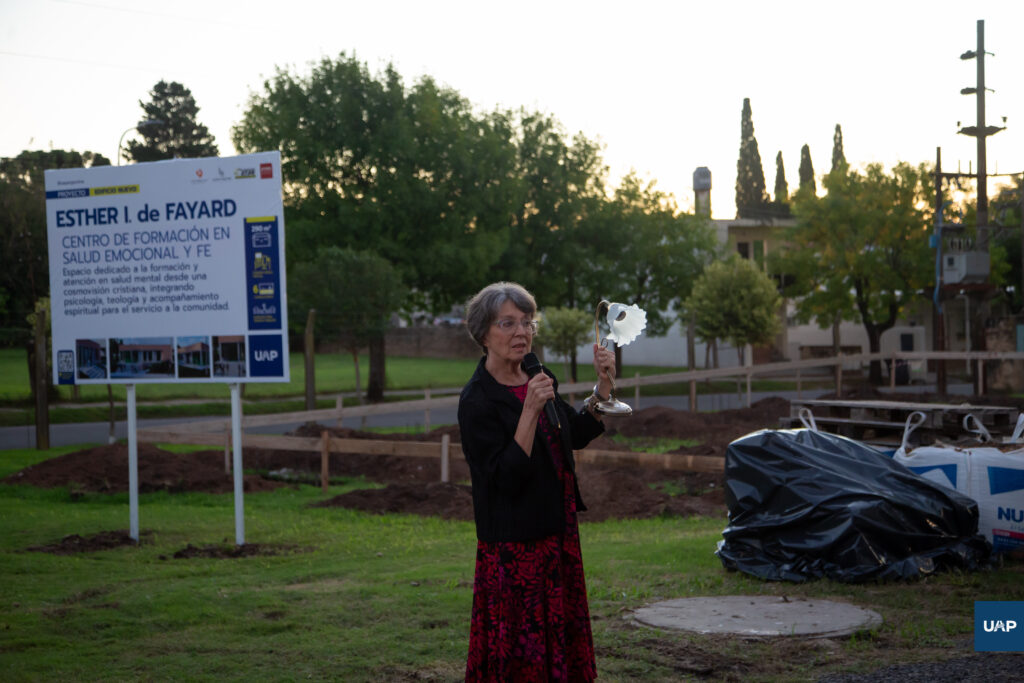 La Mag. Susana Ch. de Schulz relatando la vida y obra de Esther I. de Fayard, y sosteniendo una lámpara como símbolo de la luz que impartió en servicio a la comunidad.