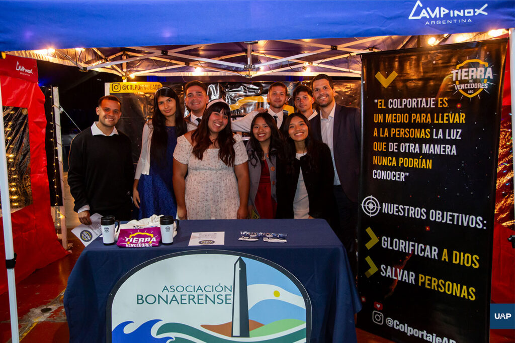 Líderes de la Asociación Bonarense y estudiantes colportores en su stand presentado en la Cena de la Victoria.